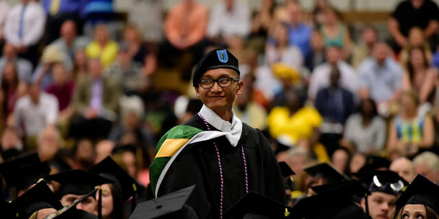 Student standing to be recognized during commencement ceremony.