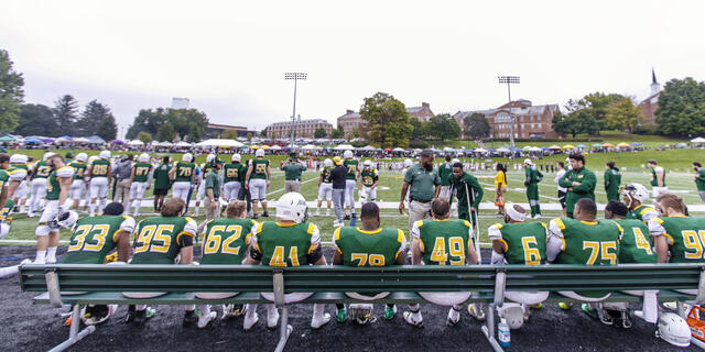 Football players sitting on the bench during football game.