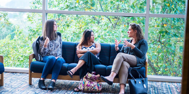 Grad students in conversation in lobby.