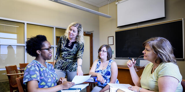 Grad professor interacting with students.