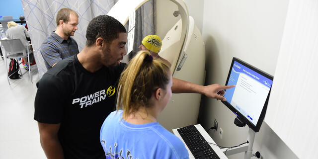 Students with professor in Kinesiology lab.