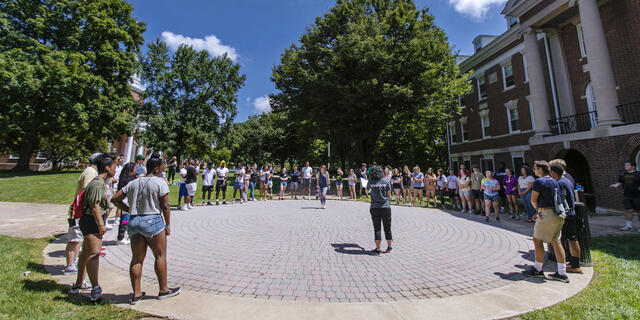 Students standing in circle on campus for McDaniel Local.