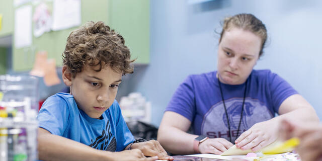 Student interacting with child at the Boys and Girls Club in Westminster.