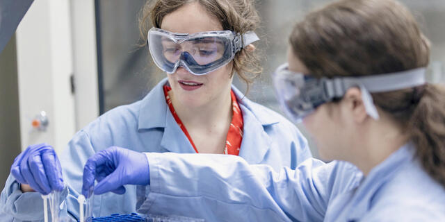 Students conducting experiment in research lab.