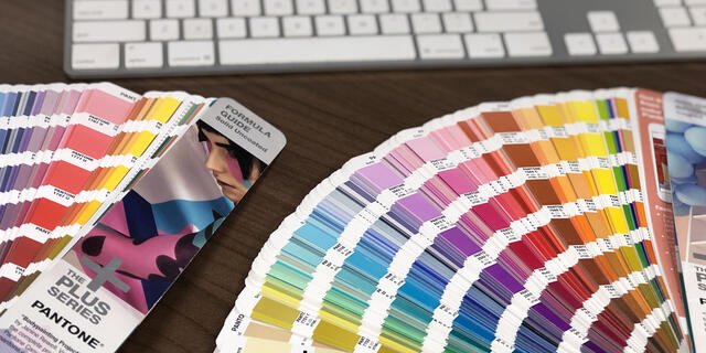 Pantone color books open on table.