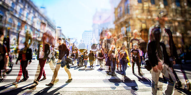 Crowd of anonymous people walking on busy city street.