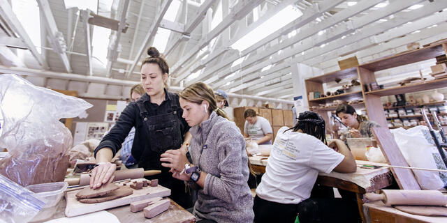 Students working on clay projects in art studio.