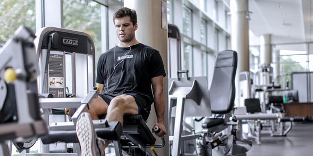 Photo of a student using a weightlifting machine in Merritt Fitness Center.