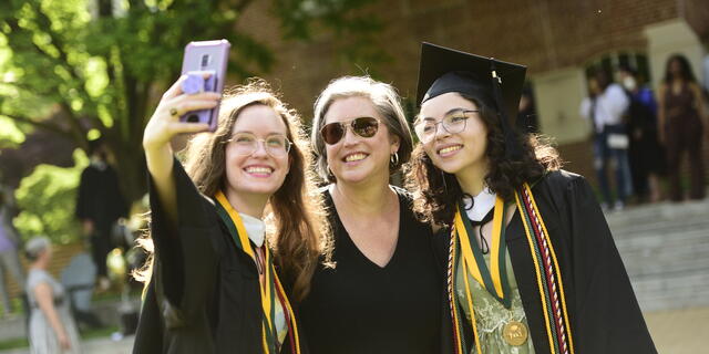 graduates and guest pose for a photo outside of the ceremony