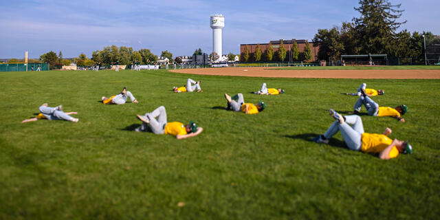 Athletes stretching on field