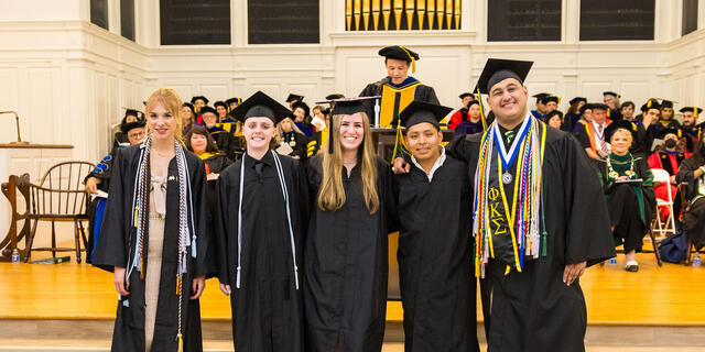 Group of students in graduation regalia pose