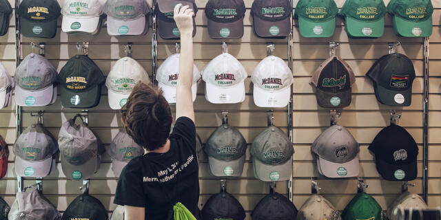 hats displayed on the wall of the campus store