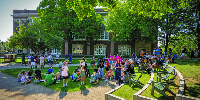 Group of students gather outside on a clear sunny day