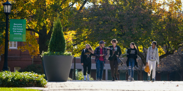 undergraduate students walking on campus in fall